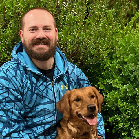 Man smiling and posing with his golden retriever